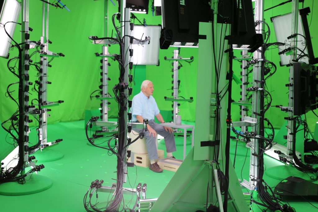 8 vertical poles with multiple cameras surround David Attenborough as he is captured volumetrically for the app.